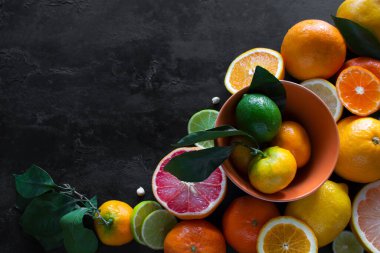Dilimlenmiş taze nargile greyfurt, mandalina ve kireç siyah bir zemin üzerinde yazılı. C vitamini kavramı