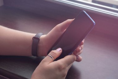 Elinde boş siyah ekran maketi olan bir akıllı telefon vardı.