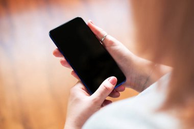 Boş ekran görüntüsü seçici odaklı cep telefonu tutan kız