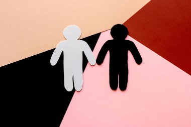 Renkli arka planda siyah beyaz karton siluetler. konsept ırkçılığı ve ayrımcılığı durdurun