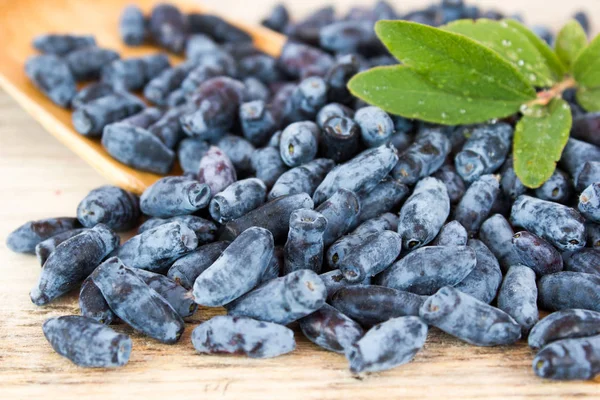 Bär av kaprifol och en träsked på ett bord — Stockfoto