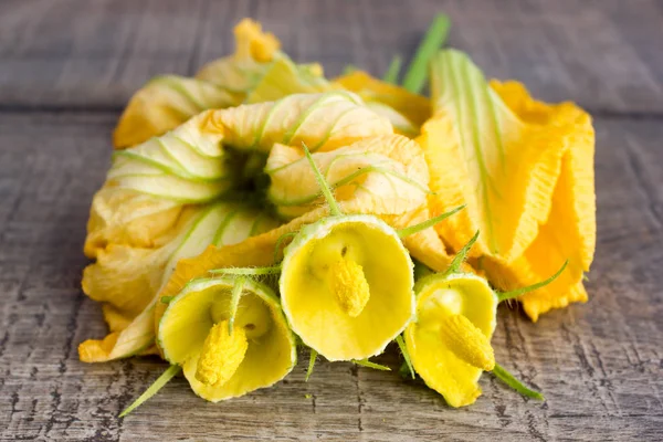 Flores amarillas de calabacín sobre una mesa de madera —  Fotos de Stock