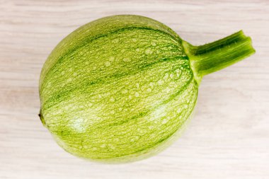 Ahşap bir masa üzerinde yuvarlak yeşil kabak