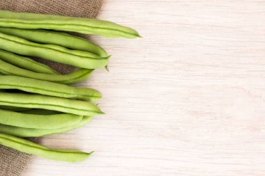 Ahşap masa üstünde çul yeşil fasulye