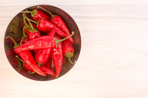 Některé červené pikantní chilli papričkami na dřevěný stůl — Stock fotografie