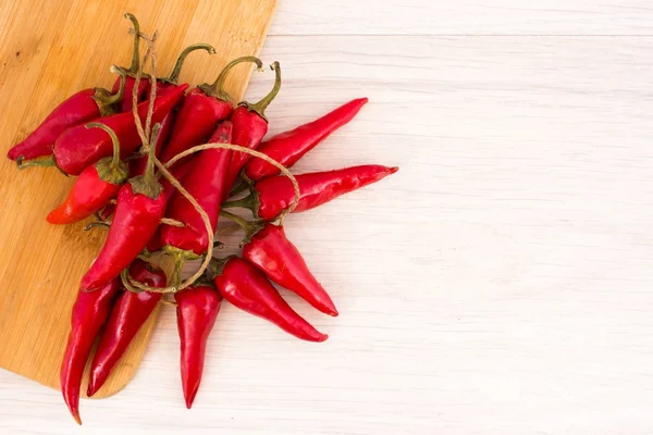 Sommige rode pittige chilipepertjes op houten tafel — Stockfoto