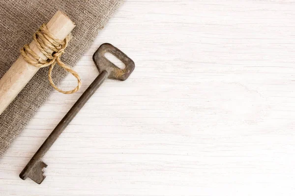 Old key on burlap on the table — Stock Photo, Image