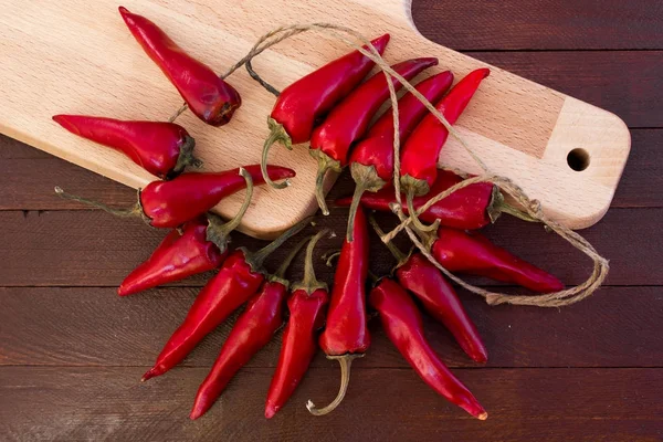 Sommige rode pittige chilipepertjes op houten tafel — Stockfoto