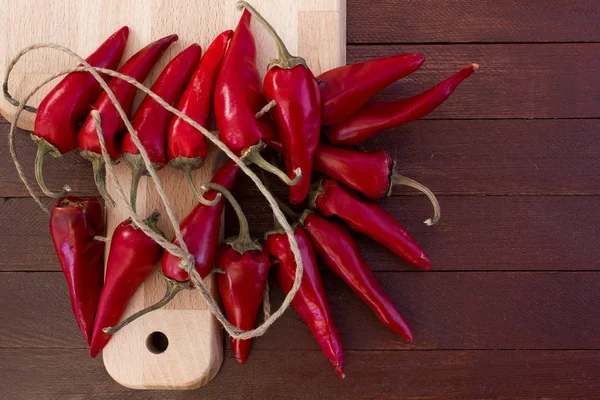 Sommige rode pittige chilipepertjes op houten tafel — Stockfoto