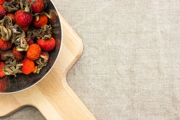 Dried berries rose hips in a bowl on burlap on the table — Stock Photo, Image