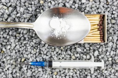 Plastik şırınga, bir kaşık ve bir maç iyi çakıl. Tıp, tıp. Uyuşturucu almaya.