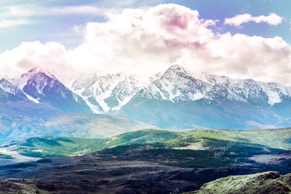 Beautiful mountain range under the clouds. Snowy peaks of rocks. View of mountain valley in Altai Republic.