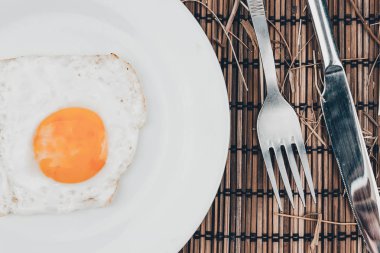 Sahanda yumurta beyaz tabak ve çatal ahşap masa üzerinde. Kafede Öğle Yemeği.