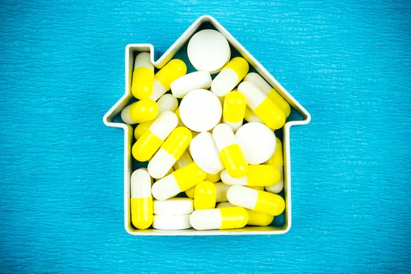 Comprimidos Brancos Amarelos Forma Casa Sobre Fundo Azul Tratamento Casa — Fotografia de Stock