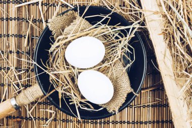 Ahşap bir masa üzerinde bir dökme demir tavada iki bütün yumurta. Yumurta pişirme.