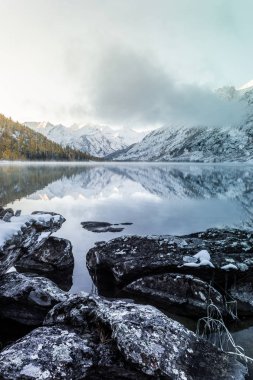 Ayna yüzey dağ gölü. Güzel doğa, Altay Cumhuriyeti Ulusal Park'ta dağlarda bir gezi. Kışın bulutlu hava.