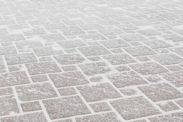 Frost ve kar altında kırmızı kiremit kaldırım. Şehir, soğuk hava buz.
