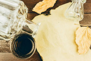 Bir şişe, bir bardak konyak ve Kraft kağıt ahşap bir masa üzerinde bir levha. Metin için yer kopyalayın