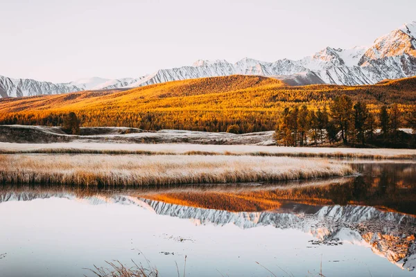 鏡面と山の谷の湖の岩のピーク カラフルな空の下で地平線の山並み 秋の天候 — ストック写真