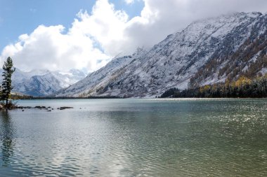 Ufukta bulutlar altında kayaçların ridge ile dağ gölü