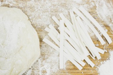 Geniş şehriye ve hamur un arka planda. Eve yemek, makarna pişirme.