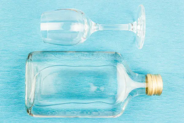 玻璃和平板玻璃瓶在蓝色背景 酒精饮料 伏特加 — 图库照片