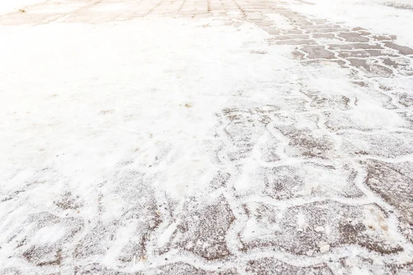 在雪下铺石板 城市人行道上的降雪和冰 — 图库照片