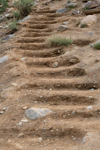 Stairs on sandy hillside. Steps carved into rock, ancient human settlement
