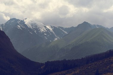 Bulutların altındaki dağ sırası. Yürüyüş ve Turizm İçin Kayalar