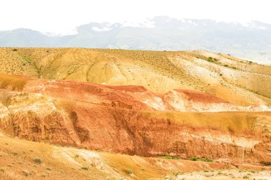 Dağ vadisindeki renkli tepeler. Sıcak yaz gününde kuru kumlu tepeler. Kuraklık, iklim değişikliği. Vadilerdeki toprak erozyonu