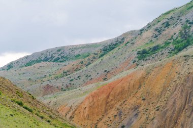 Kırmızı kumlu yamaçlı bir kanyon. Toprak erozyonu olan çöl tepeleri, kuraklık nedeniyle vadi oluşumu.