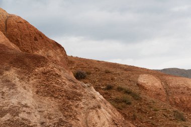 Kanyondaki kırmızı tepeler. Kırmızı renkli kayalar. Vadideki eski nehir yatağı.