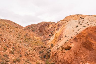 Kuru nehir yatağının kanyonundaki kayalar. İklim değişikliği yüzünden kuraklık. Tepelerin toprak erozyonu. Dağlarda kırmızı kum
