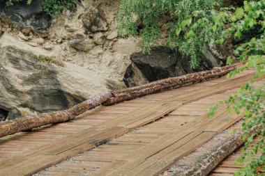 Bridge of logs and sleepers. Wooden flooring for transportation. Ecological road without asphalt clipart