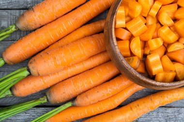 Tahta masada taze havuç, vejetaryen yemekleri pişirmek, sebze yetiştirmek.