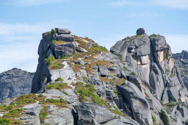 Mavi bulutlu gökyüzünün altındaki kaya sırtı, dağ turizmi, dinlenmek için turistik alan