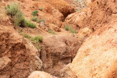 Kuru nehir yatağının kanyonundaki kayalar. İklim değişikliği yüzünden kuraklık. Tepelerin toprak erozyonu. Dağlarda kırmızı kum