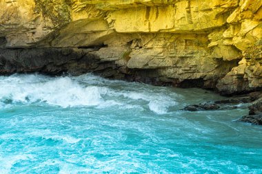 Mavi kaynayan su kayalara, deniz sörfüne, dağ nehrinin hızlı akışına, okyanus dalgalarına çarpar.