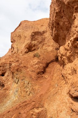 Kuru nehir yatağının kanyonundaki kayalar. İklim değişikliği yüzünden kuraklık. Tepelerin toprak erozyonu. Dağlarda kırmızı kum