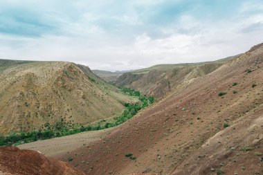 Kibar kırmızı tepeler, dağ vadisinde yolculuk hayvanlar için otlaklar kurak bozkırlarda toprak erozyonu.