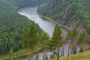 wide river between green hills, smooth bend of riverbed, contemplation of nature for meditation and relaxation