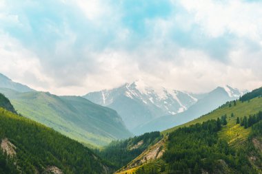 Bulutlarla dolu bir tepe. Kar yamaçlı kayalar, dağ manzarası. Ülke çapında turizm gezisi