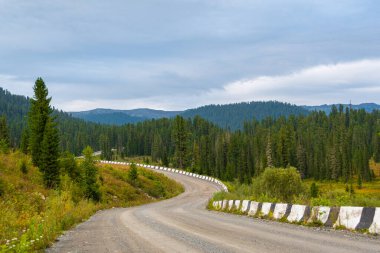 Taştan güvenlik bariyeriyle toprak dağ yolunu kıvır