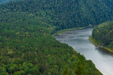 wide river between green hills, smooth bend of riverbed, contemplation of nature for meditation and relaxation