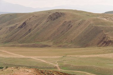 Kibar kırmızı tepeler, dağ vadisinde yolculuk hayvanlar için otlaklar kurak bozkırlarda toprak erozyonu.