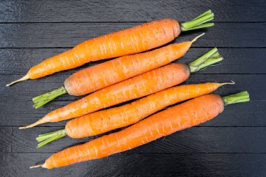 Tahta masada taze havuç hasat ettikten sonra, vejetaryenler için yemek pişirdikten sonra, sağlıklı yiyecekler. Bahçede sebze yetiştiriyorum.