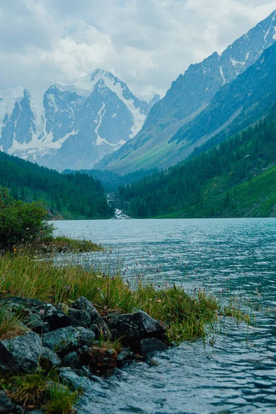 在地平线上有山峰和山脊的湖 在山上爬山爬山 在蓝色的水面上有石崖 — 图库照片