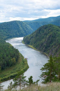 wide river between green hills, smooth bend of riverbed, contemplation of nature for meditation and relaxation