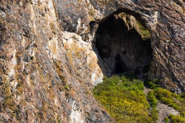 Dağ yamacında küçük bir mağara ya da mağara, dağcılık ve kayaların içine mağara.