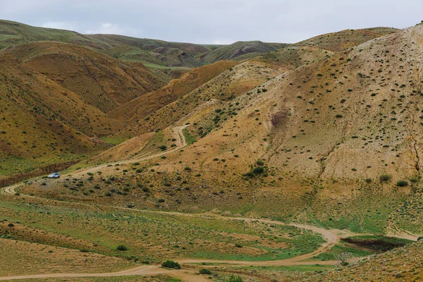 草原の黄色の丘や峡谷雲の下の乾燥した風景土壌浸食の痕跡を持つ山ヤギや羊の牧草地 — ストック写真